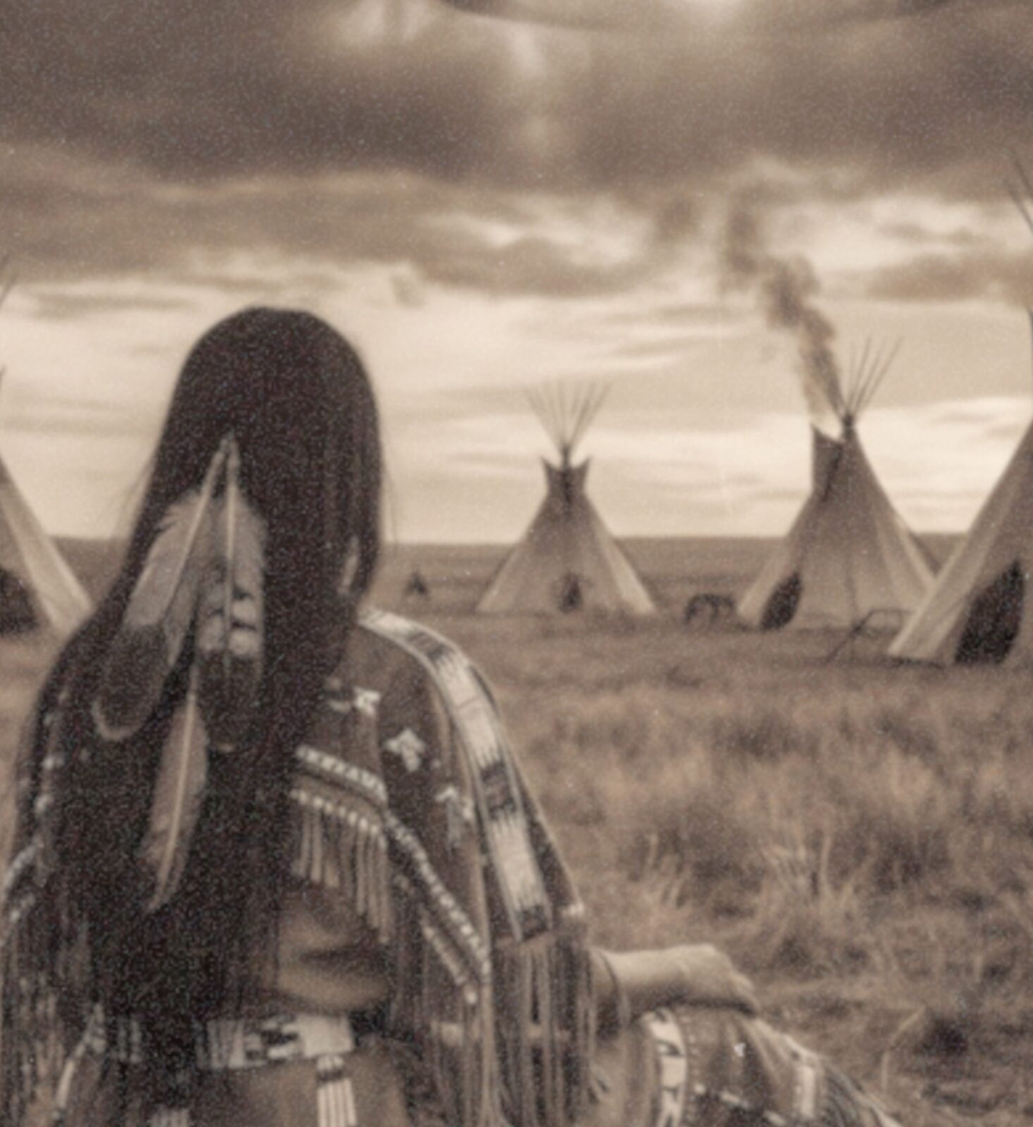 Close-up detail of a sepia-toned fine art print showing a Native American woman from behind, wearing intricately detailed fringed and beaded traditional clothing, seated in open prairie grass as a row of tepees and a massive dark UFO glowing beneath stormy clouds fill the horizon behind her, revealing the rich aged texture and warm vintage tones of this surreal Western art print.