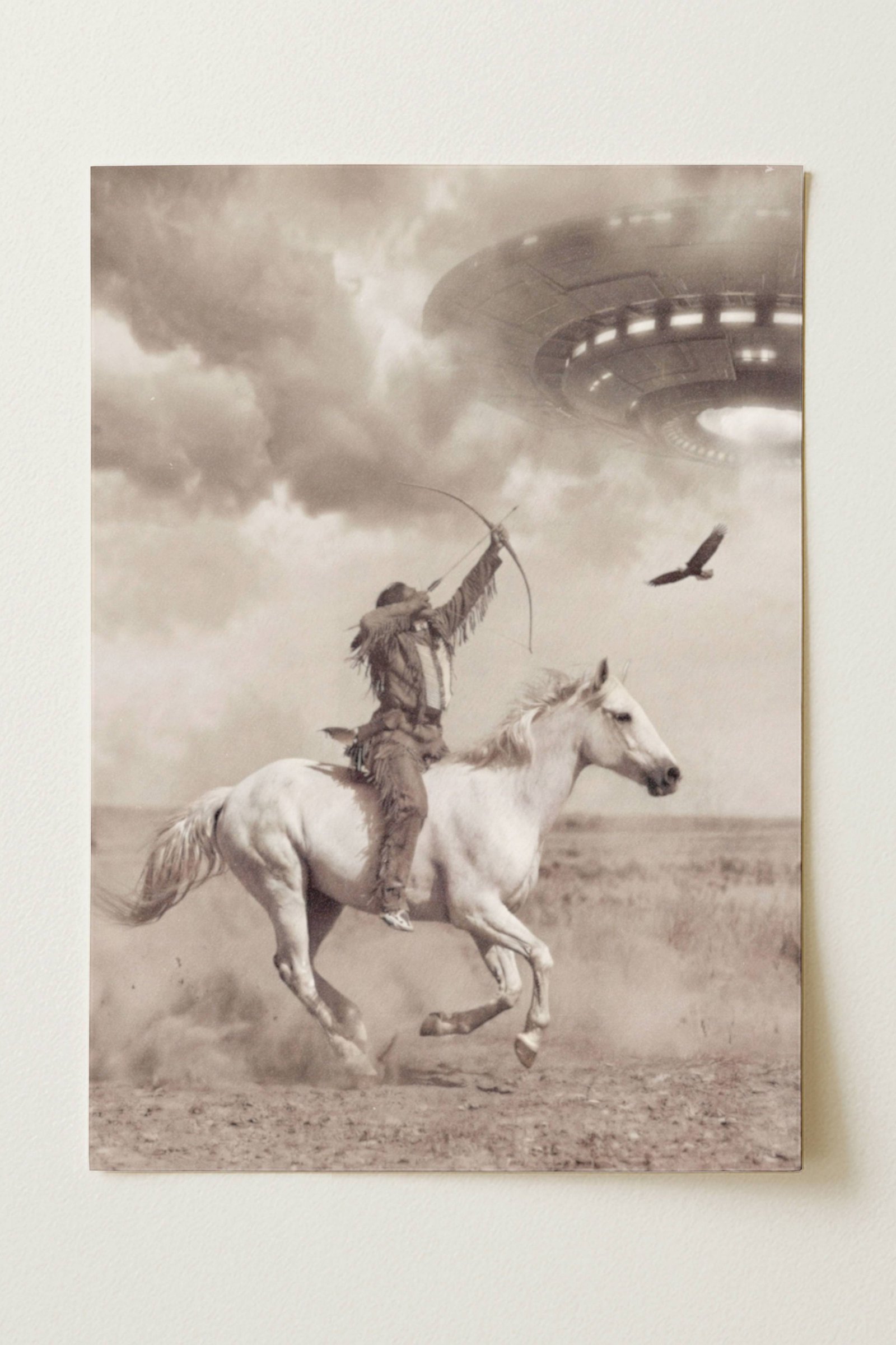 Sepia-toned fine art print photographed flat as a sheet of paper, showing a Native American warrior on horseback drawing a bow toward a large glowing UFO in a stormy sky, with an eagle soaring beside him over a dusty prairie landscape. The flat lay highlights the vintage aged texture, warm tonal tones and fine detail of this surreal Western art poster printed on premium matte paper.