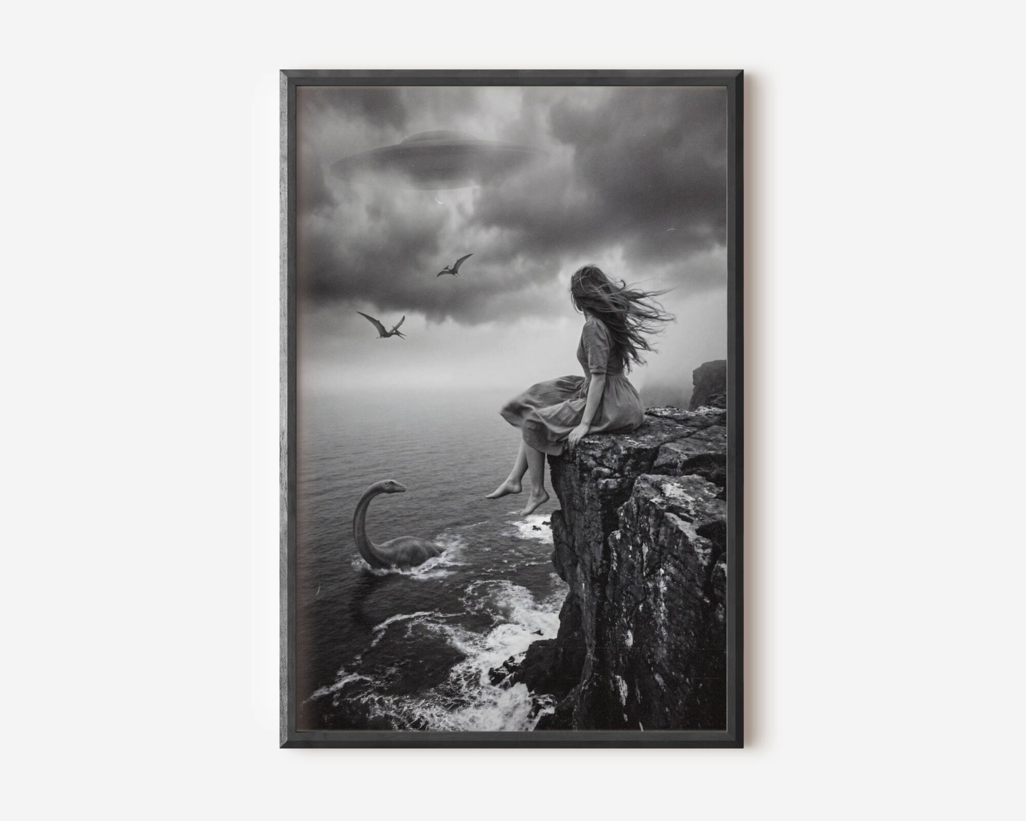 Premium dark surreal black and white poster of a barefoot windswept woman on a dramatic coastal cliff with a plesiosaur rising from stormy waves below, pterodactyls circling and a UFO drifting through dark storm clouds — hauntingly beautiful dark surreal wall art – unframed dark surreal art poster, ufoposter.com