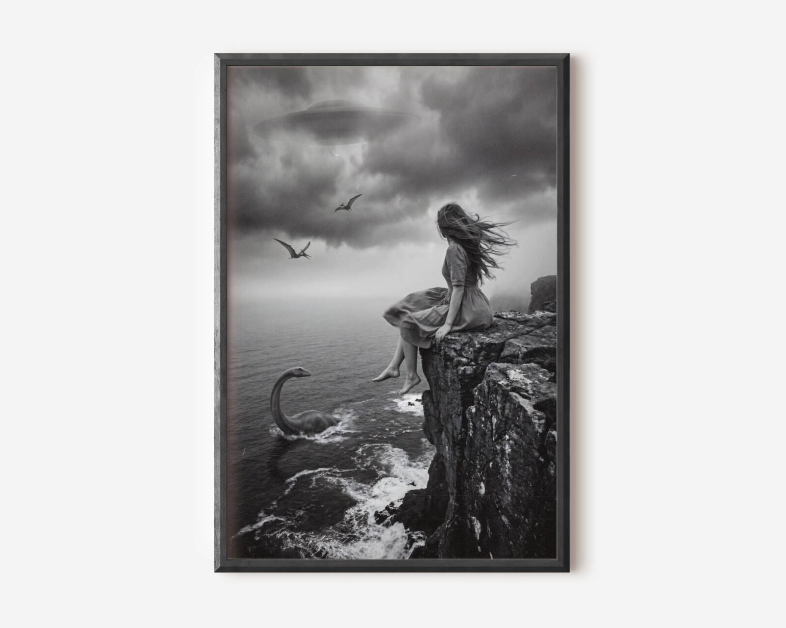 Premium dark surreal black and white poster of a barefoot windswept woman on a dramatic coastal cliff with a plesiosaur rising from stormy waves below, pterodactyls circling and a UFO drifting through dark storm clouds — hauntingly beautiful dark surreal wall art – unframed dark surreal art poster, ufoposter.com