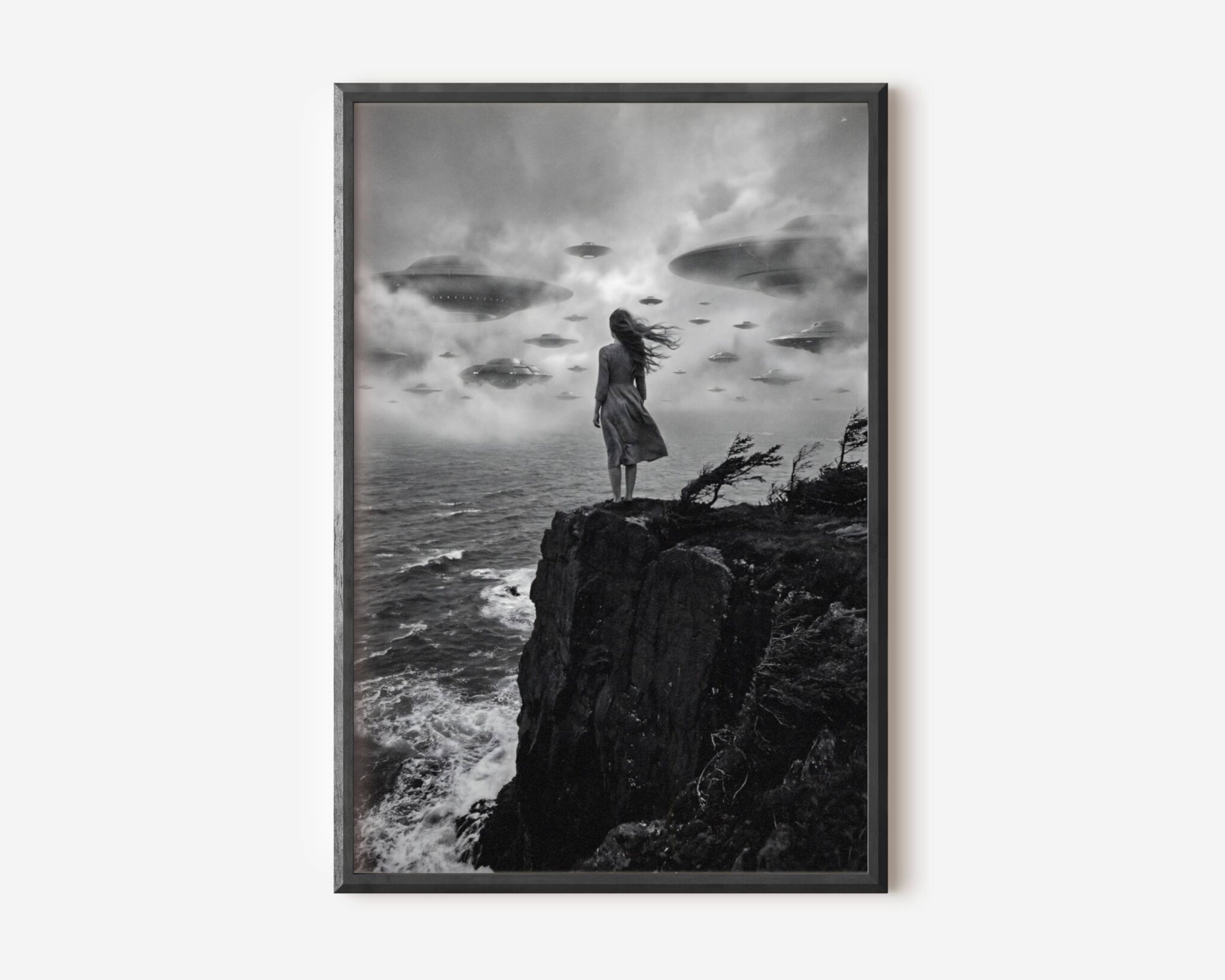 Black and white fine art print showing a woman with long windswept hair standing with her back to the viewer, facing a dramatic fleet of UFO spacecraft hovering in a misty sky. Printed on premium matte paper with rich deep blacks and subtle grey tones, this cinematic sci-fi poster brings atmospheric tension and artistic depth to any wall.