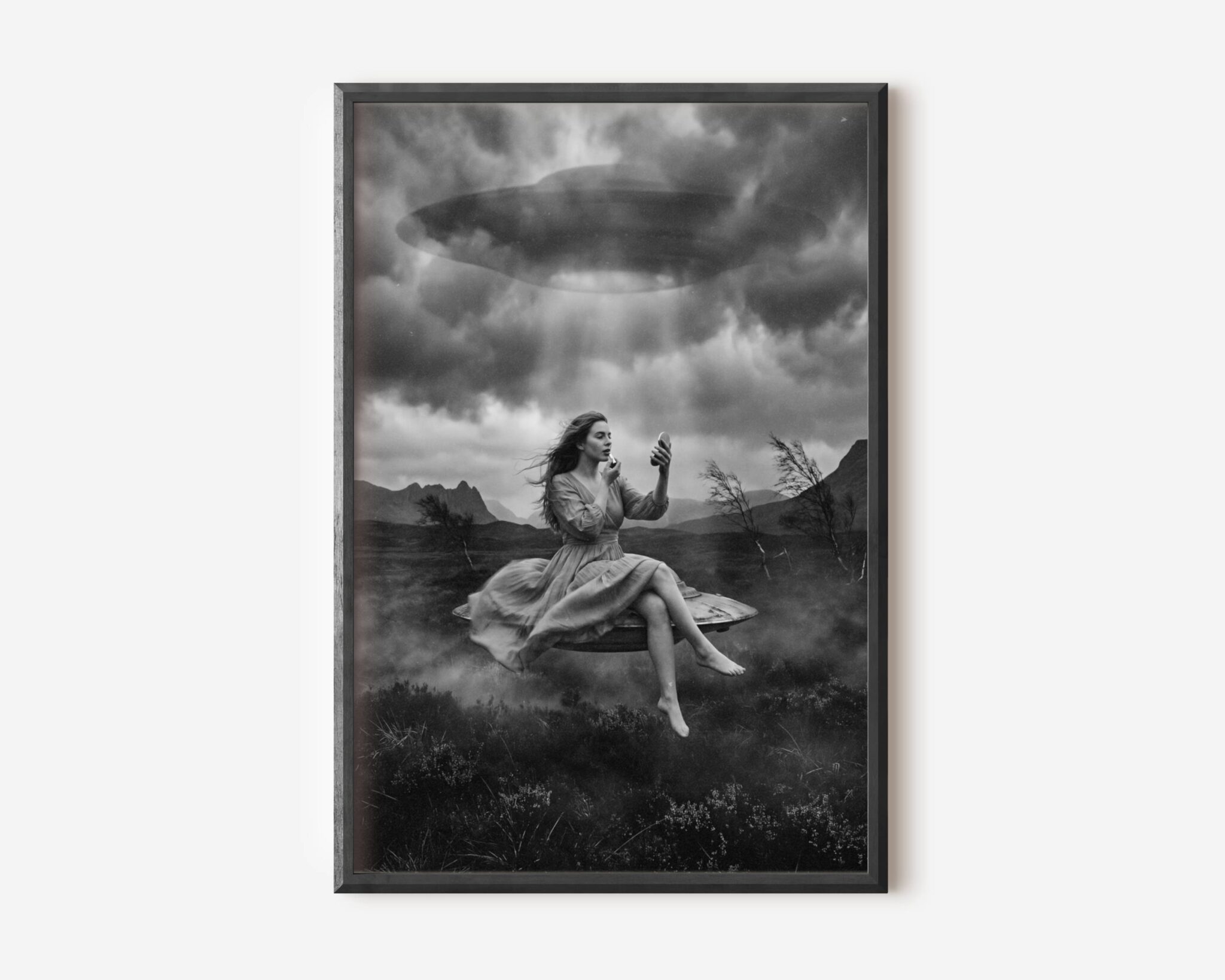 Black and white fine art print of a woman in a flowing dress sitting barefoot on a levitating surface, calmly applying lipstick while looking into a small mirror, as a large UFO hovers above her in a stormy sky over a dark misty landscape. A surreal and darkly humorous cinematic sci-fi wall art print printed on premium matte paper.