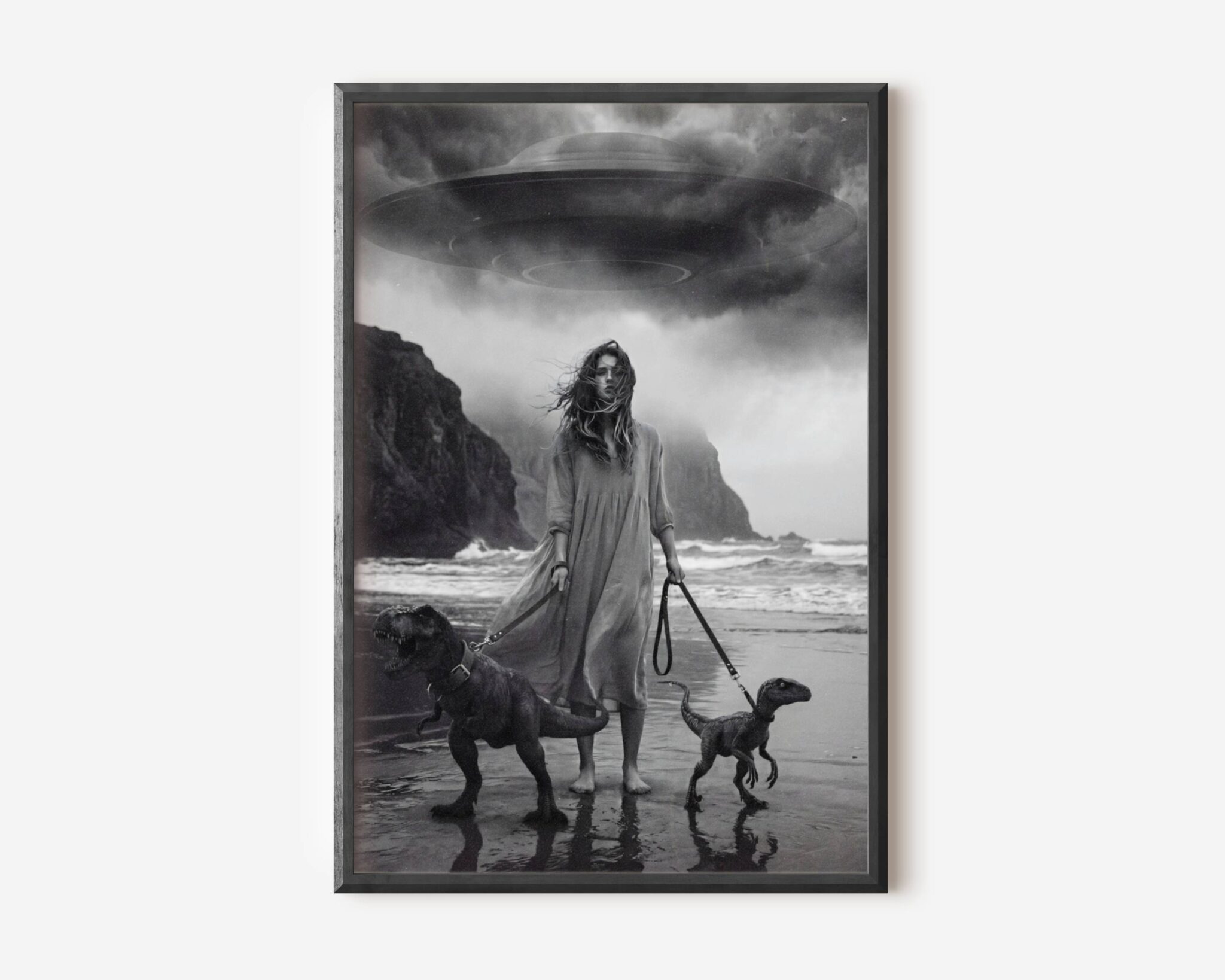 Black and white fine art print of a woman in a flowing dress standing on a dramatic stormy beach, her long hair blown across her face by the wind, with towering dark cliffs and crashing waves behind her. A cinematic and emotionally charged wall art print printed on premium matte paper.