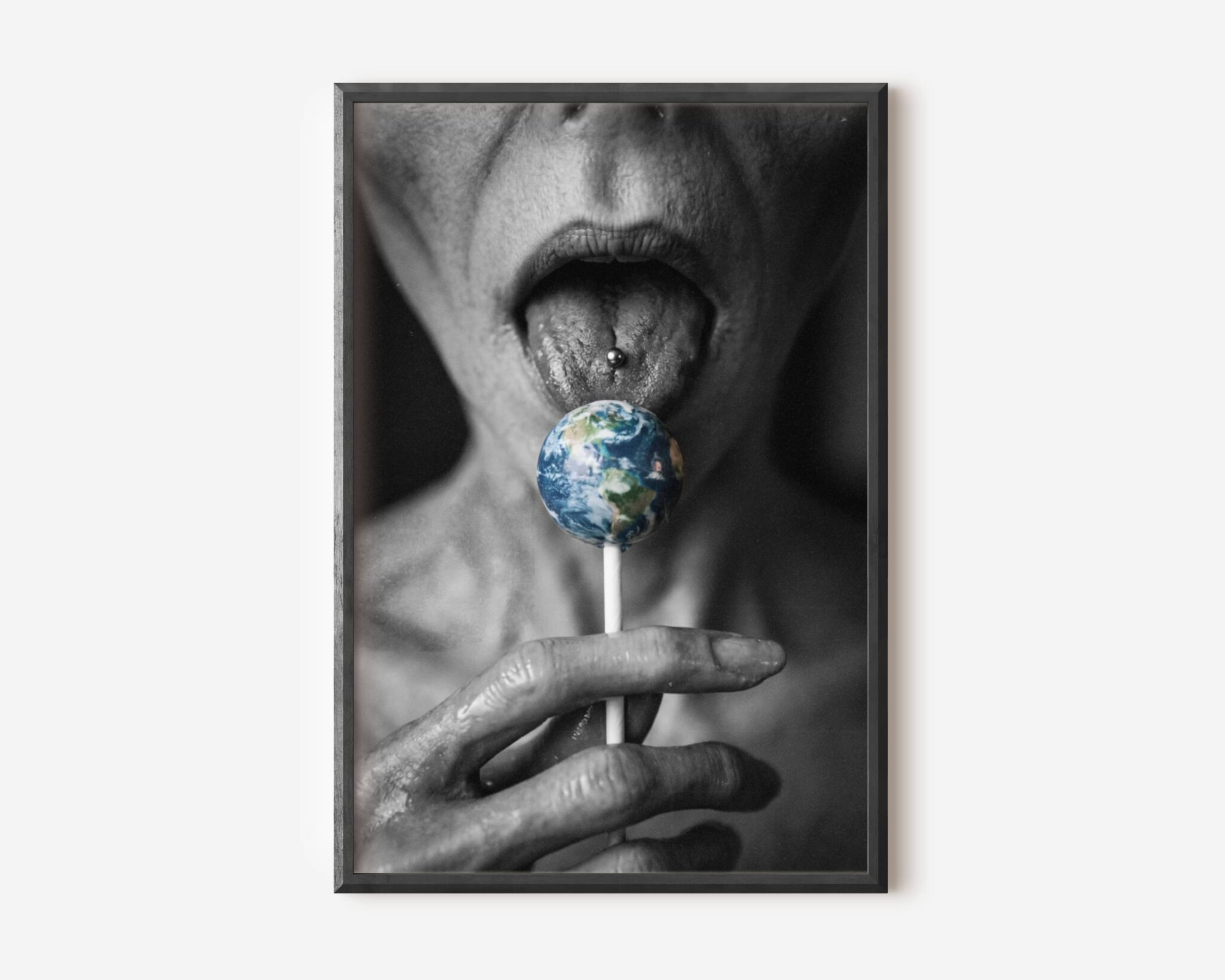 Premium dark concept poster of a grey alien licking a lollipop shaped like planet Earth, combining sci-fi humour with dark surreal aesthetics in a striking close-up composition – unframed alien art poster, ufoposter.com