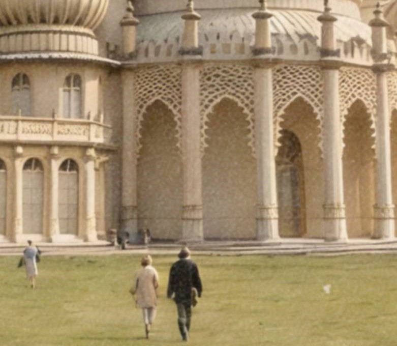 Intense warm-toned vintage close-up of a massive UFO emerging from hazy golden clouds directly above the ornate domes and minarets of Brighton Royal Pavilion – unframed retro alien portrait poster, ufoposter.com
