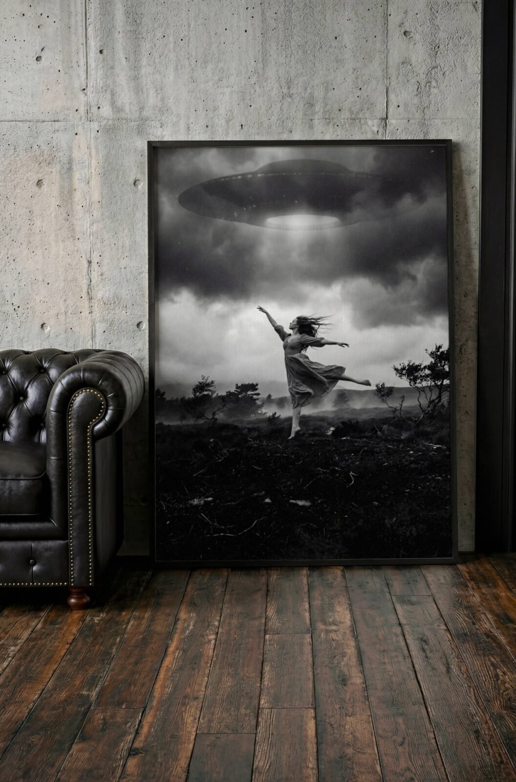 Black and white surreal art print of a woman dancing beneath a hovering UFO with a glowing beam of light over a dark moorland landscape