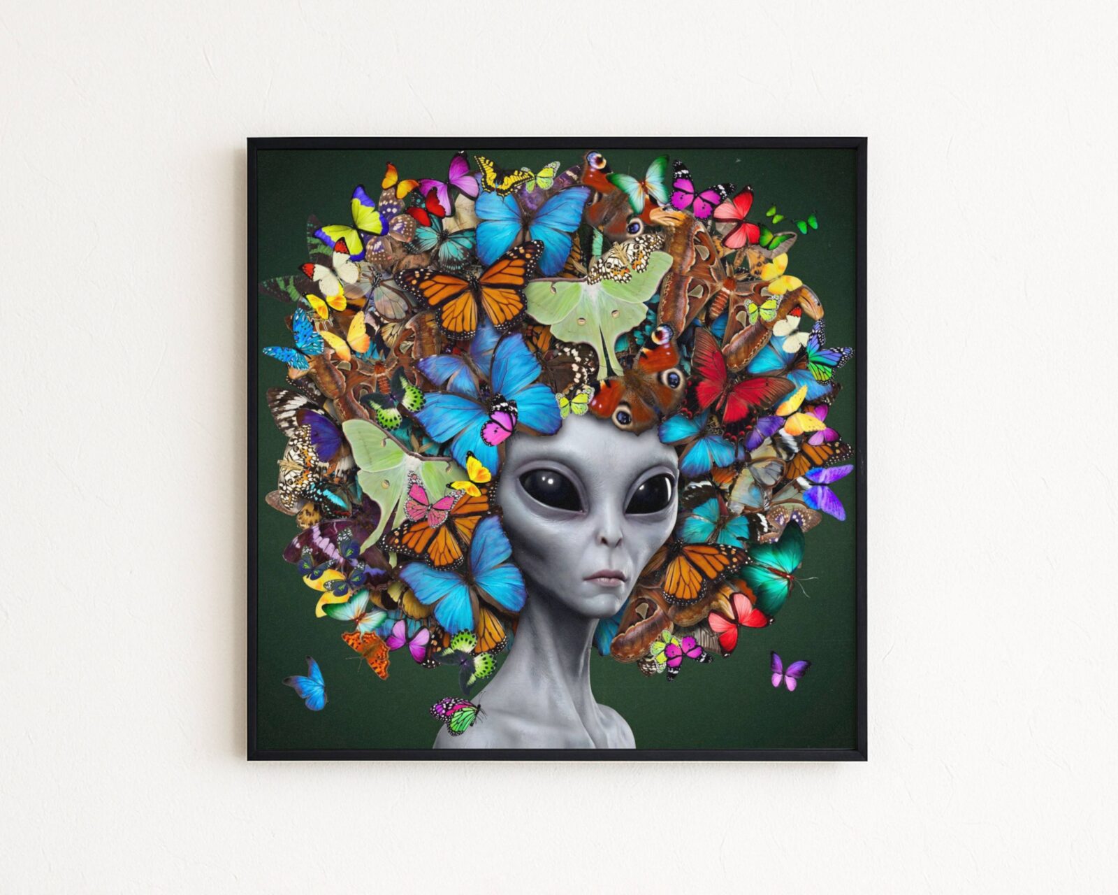 Premium bold surreal portrait of a grey alien with calm dark eyes crowned with an extraordinary explosion of colourful butterflies — monarchs, morphos, luna moths and peacock wings layered in blue, orange, green, pink and gold against deep forest green — a genuinely unique and joyful alien butterfly wall art print – unframed colourful alien art poster, ufoposter.com