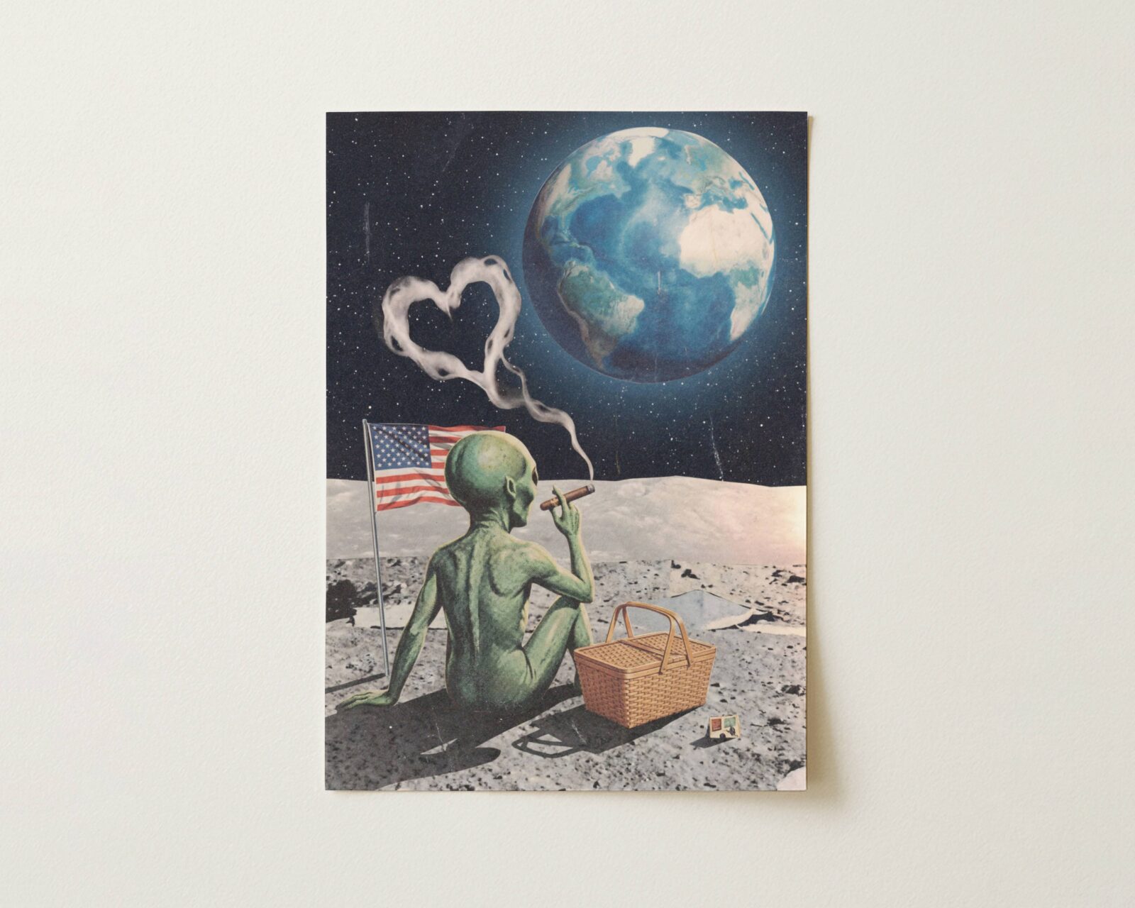 Flat print dark cinematic retro collage of a green alien on the Moon with a cigar, heart-shaped smoke, an American flag and picnic basket as planet Earth glows blue in the starry black sky — high quality unframed flat poster print, ufoposter.com