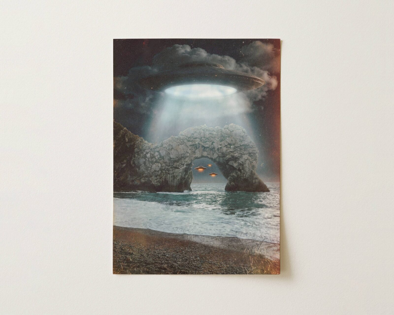 Flat print dramatic dark retro artwork of a massive UFO above Durdle Door beaming blue-white light through storm clouds onto the iconic Dorset limestone arch, two smaller glowing spacecraft visible through the arch over a churning sea — high quality unframed flat poster print, ufoposter.com