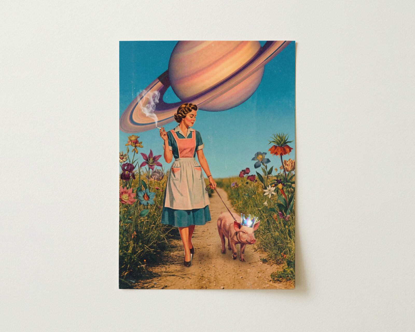 Flat print warm pastel vintage retro collage of a 1950s housewife walking a crown-wearing pig on a flower-lined country path beneath an enormous ringed Saturn planet — high quality unframed flat poster print, ufoposter.com