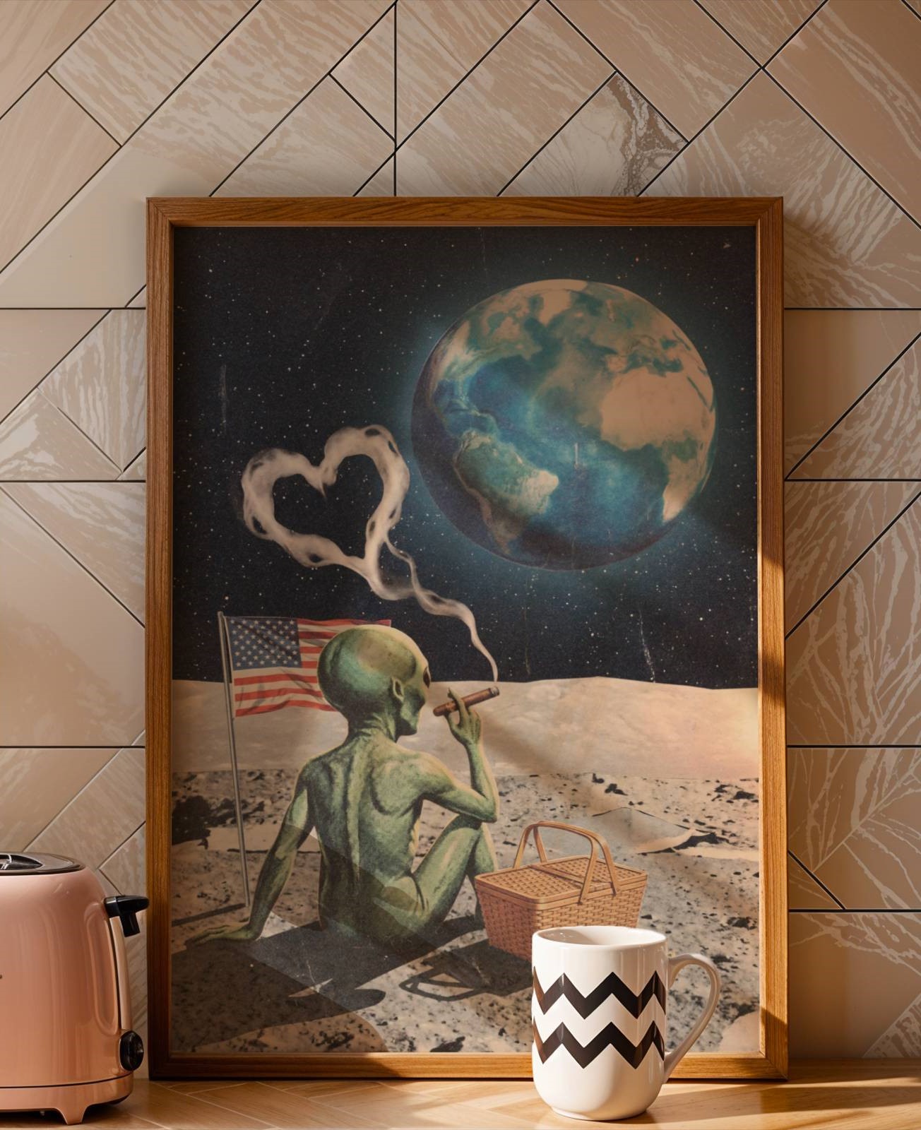 Dark retro collage of a green alien sitting cross-legged on the Moon smoking a cigar with heart-shaped smoke, an American flag planted in the lunar dust and a picnic basket beside him as planet Earth glows blue in the starry sky — a brilliantly funny retro kitchen wall art print – unframed funny retro poster for kitchen, ufoposter.com