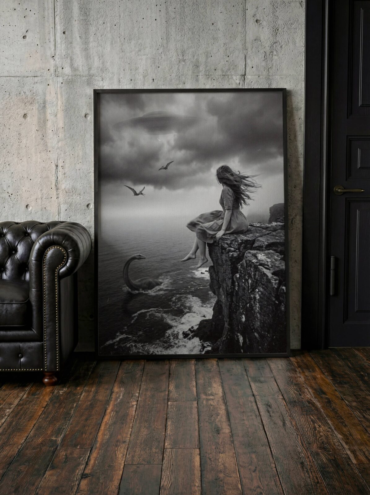 Atmospheric black and white surreal artwork of a windswept barefoot woman sitting on a dramatic coastal cliff as a plesiosaur rises from stormy crashing waves below and pterodactyls and a UFO fill the dark storm clouds above – unframed dark surreal alien wall poster, ufoposter.com