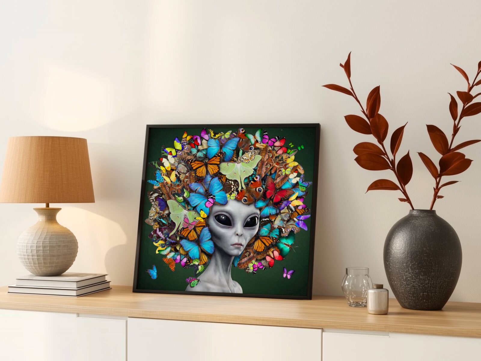 Deeply vibrant surreal portrait of a grey alien with large dark eyes and an extraordinary headdress of layered colourful butterflies in every species against a deep forest green background — a genuinely unique and joyful alien art print – unframed colourful surreal alien wall poster, ufoposter.com