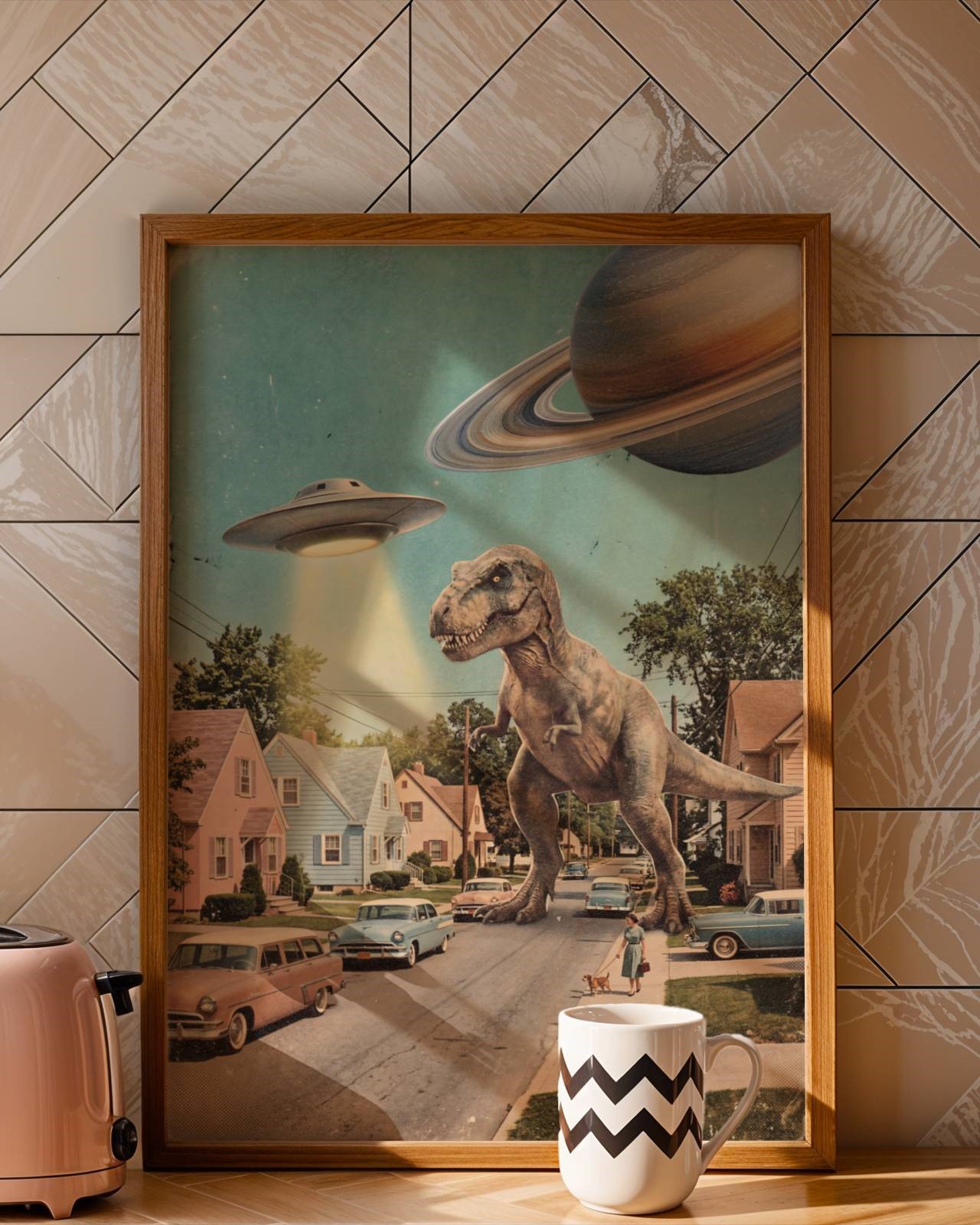 Bold retro collage of a colossal T-Rex walking down a perfectly ordinary 1950s suburban street with a UFO beam blazing above the rooftops and Saturn in the corner of a pastel blue sky — a hilarious and distinctive retro kitchen wall art print – unframed retro collage art for kitchen, ufoposter.com